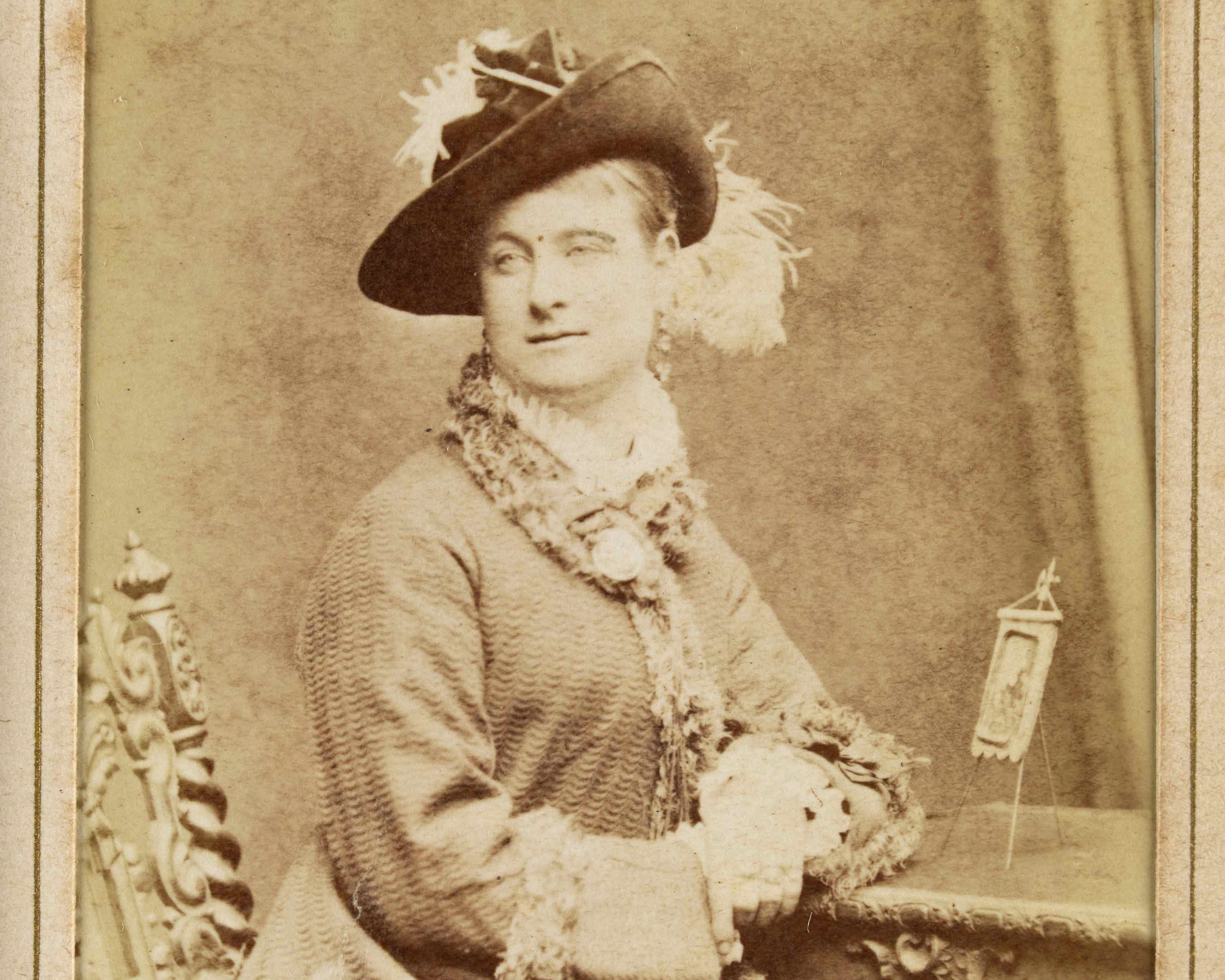 Black and white studio portrait of a woman sitting at a desk