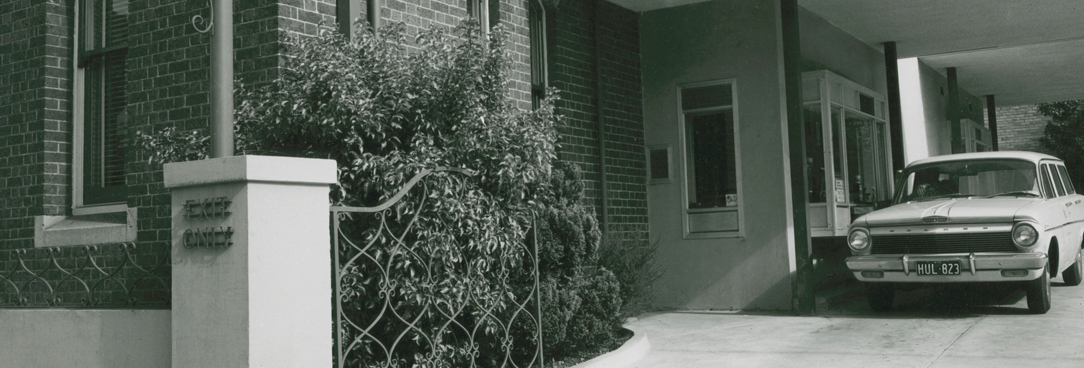 a black and white photograph of a car driving through the ES&A Bank Drive in
