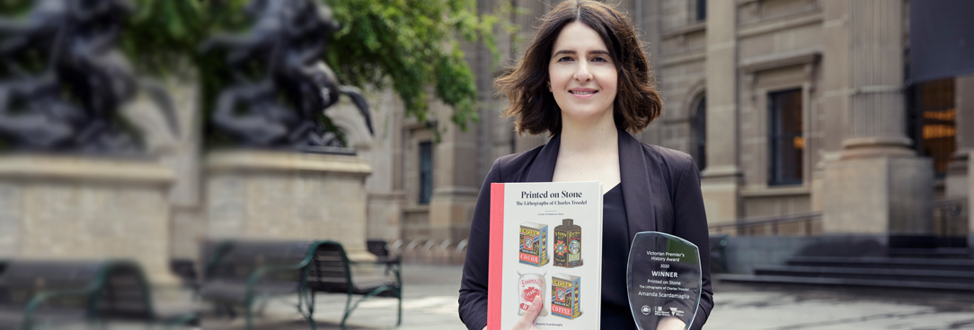 woman holding a book and trophy