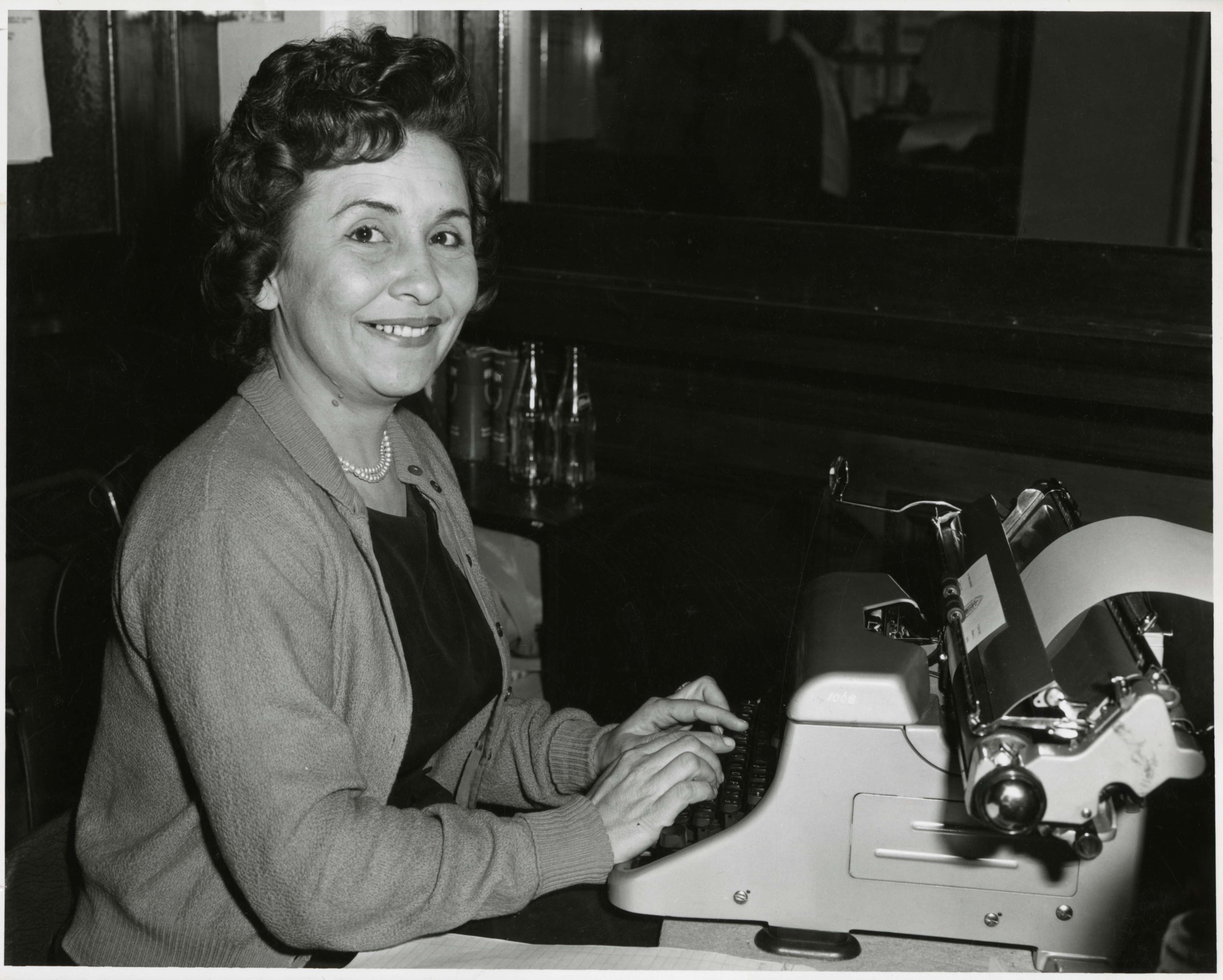 black and white photo of woman at a typewriter