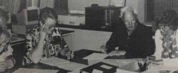 Some of the volunteers who have worked on shipping lists over the years black and white photo of volunteers looking over documents