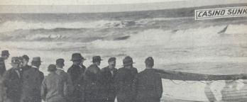 a crowd gathers at the water's edge to view the wreckage of the SS Casino