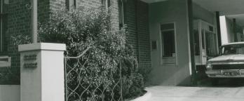 a black and white photograph of a car driving through the ES&A Bank Drive in