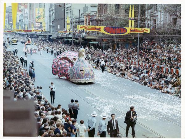 a colourful float in the road crowds either side