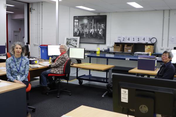 Three volunteers sitting at desks