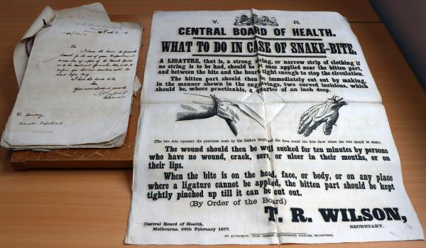a letter on a table beside a large poster