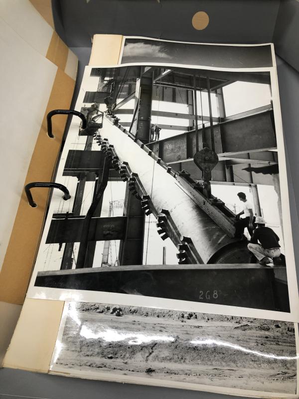 black and white photo, in an album, of a construction site