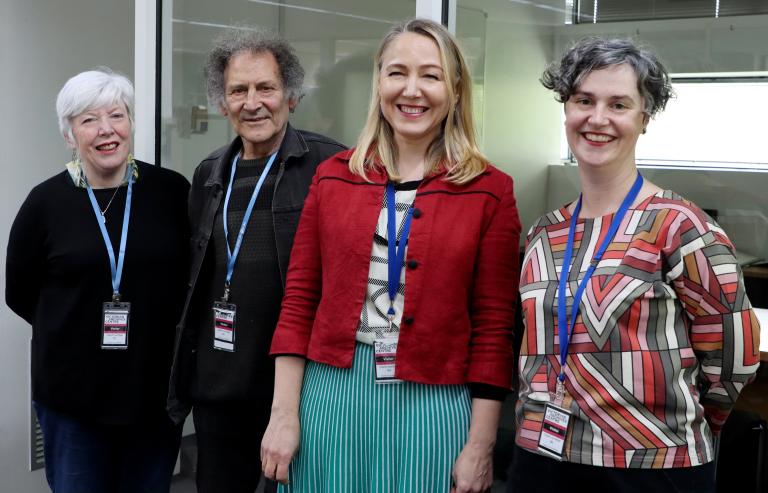 Group of four people smiling indoors
