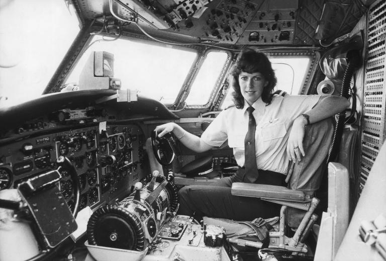 "Black and white photograph of Deborah Lawrie in the cockpit of a plane, turned to face the camera""