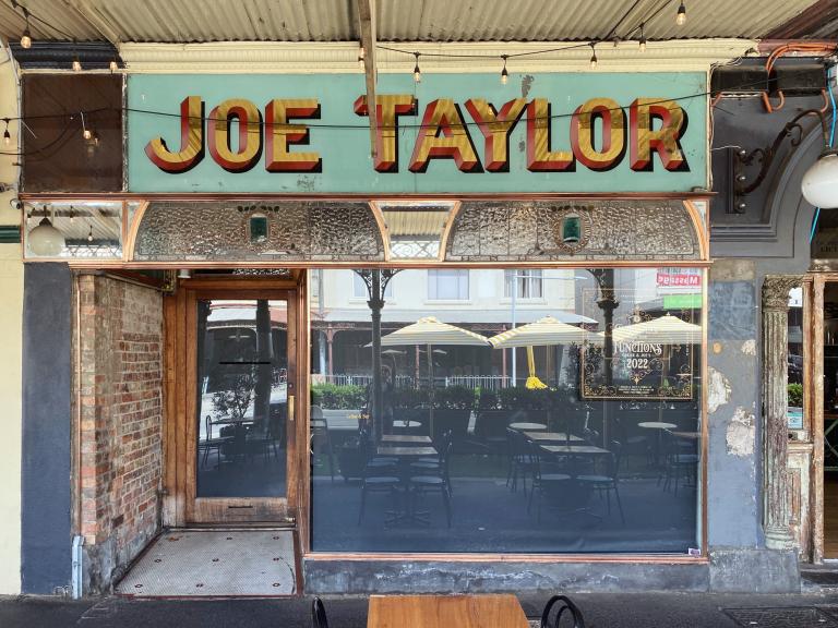 A contemporary photograph of an old window sign for Joe Taylor on Errol Street North Melbourne