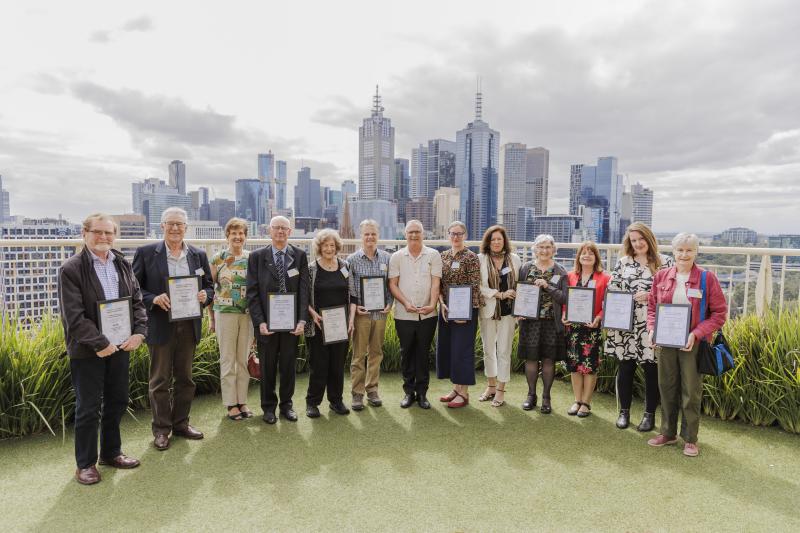 winners standing in a line outside the Langham hotel balcony overlooking Melbourne city scape