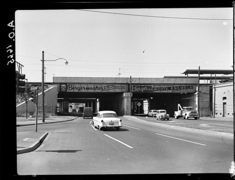 cars driving under railway bridge